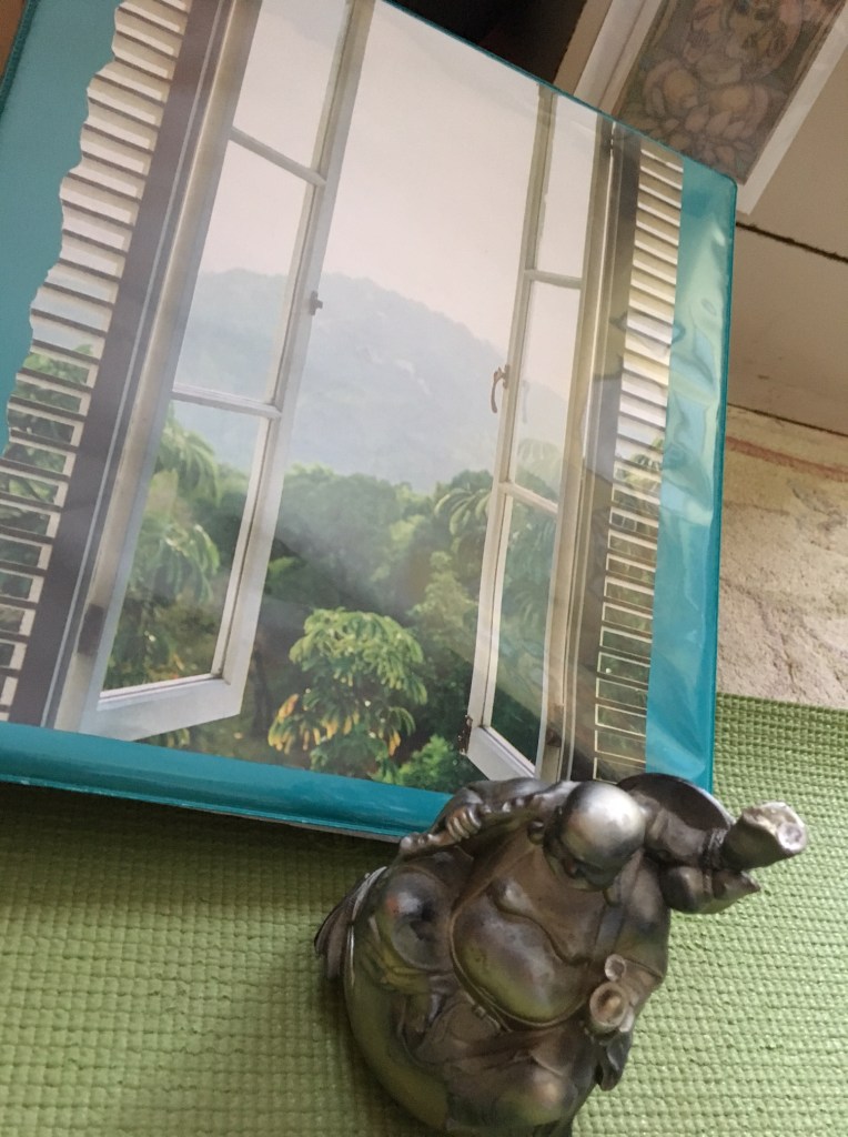 Buddha by the window on my yoga routine notebook.