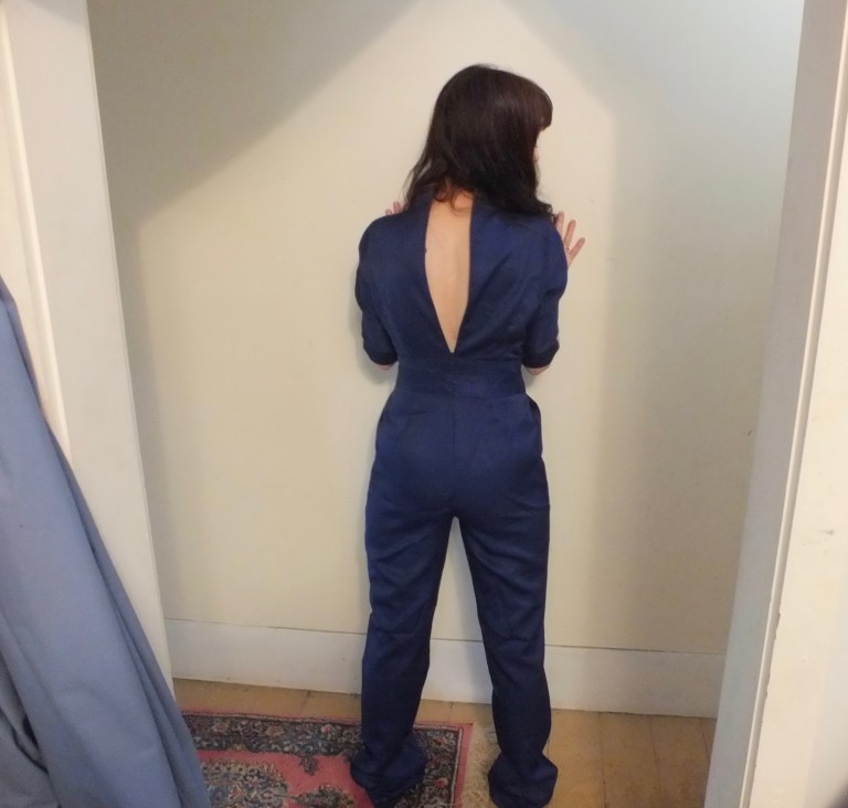navy blue jumpsuit from an online Shanghai-based company called Rotital a woman with her back to the camera with a gaping zipper on the jumpsuit.